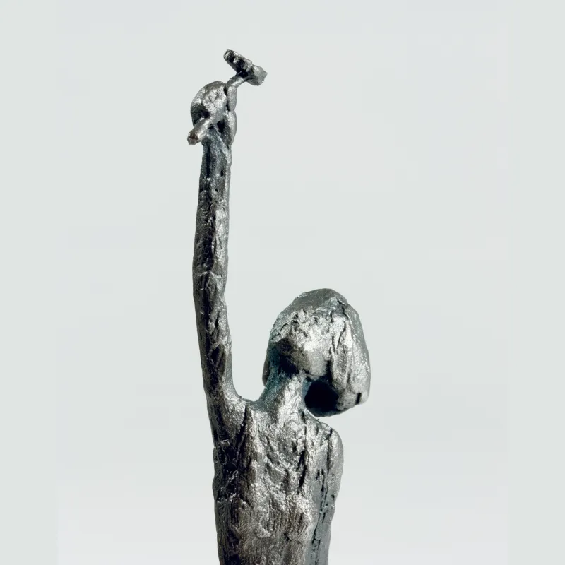 Susanne Kraißer Blumenmädchen, Nahaufnahme des Oberkörpers von schräg hinten mit erhobenem Arm und rauer Silberoberfläche