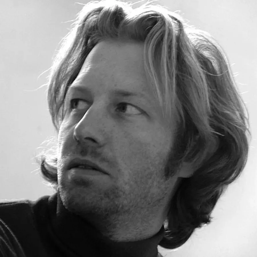 Black-and-white portrait of the sculptor Tomas Medek with shoulder-length hair