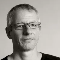 Black-and-white portrait of the sculptor Matthias Eder wearing glasses